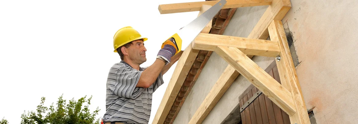 Person baut ein Vordach aus Holz